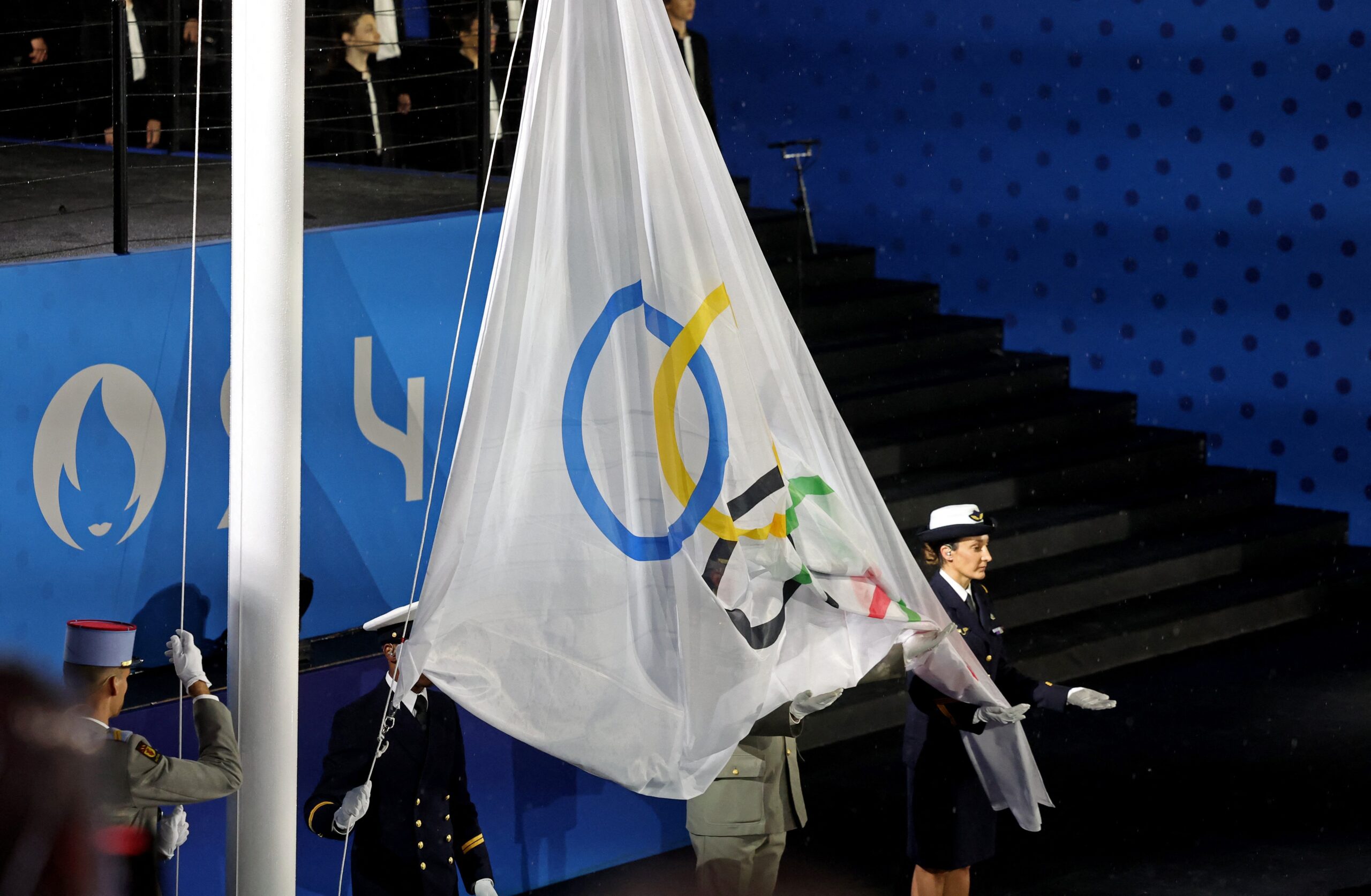 Bandeira olímpica é hasteada de cabeça para baixo na abertura das Olimpíadas