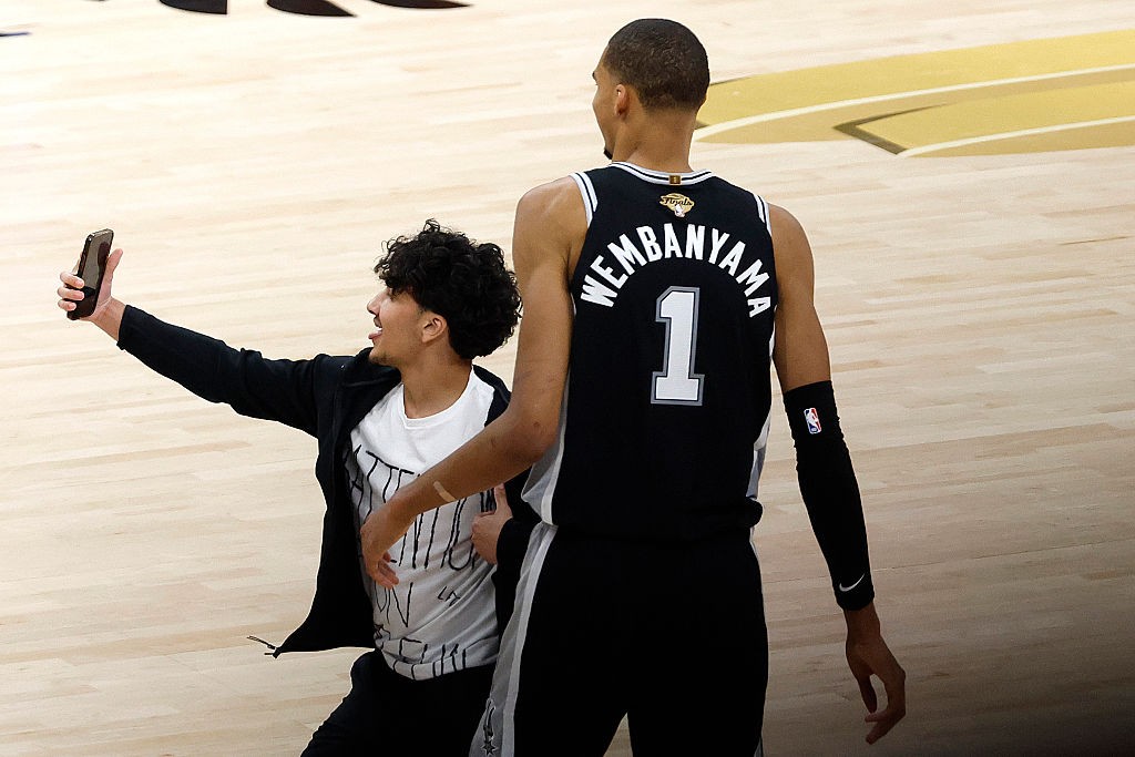 Torcedor invade a quadra para tirar selfie com Wembanyama durante as finais da NBA; Knicks vencem Spurs