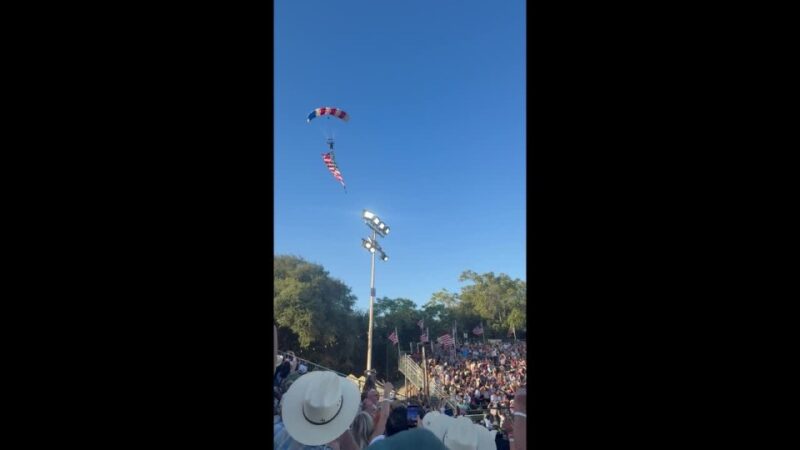 VÍDEO: Paraquedista amarrado à bandeira gigante dos EUA se enrosca em árvore e cai sobre tenda
