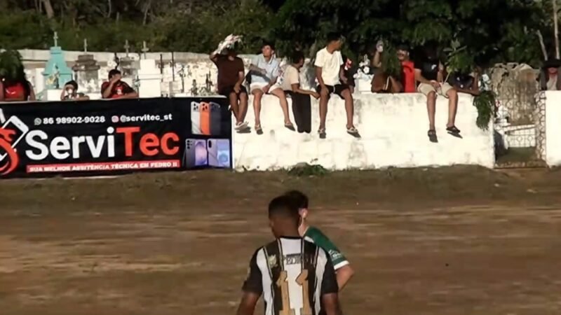 Torcedor usa coroa de flores para fugir do sol em jogo amador ao lado do cemitério no Piauí